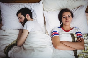 Woman suffering from insomnia and lying awake in bed at night