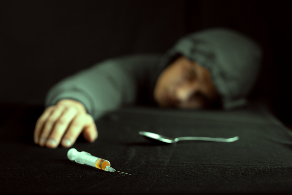 Adult sitting alone in distress, representing depression and emotional struggles linked to chronic drug abuse.