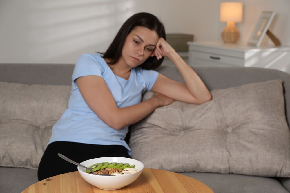Rumination disorder digestive process food returning from stomach to mouth making woman unhappy about food.