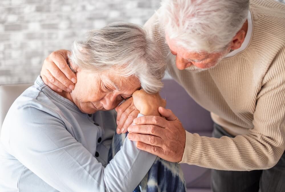Elderly person receiving help from a caregiver at home, illustrating daily support for Lewy body dementia patients