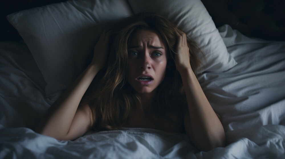 Woman struggling to breathe during panic attack in bed at night