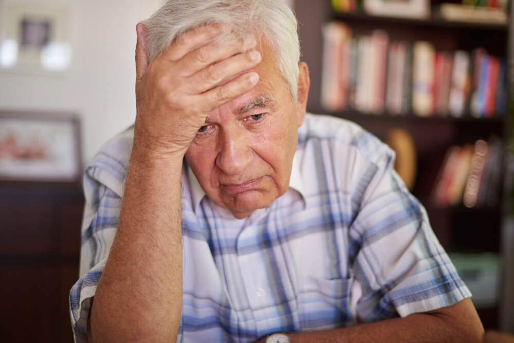Senior man looking down and withdrawn, showing signs of depression and low mood in aging
