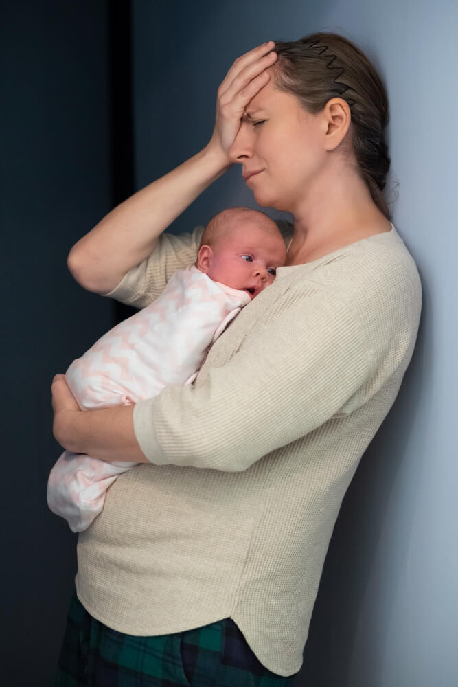 Anxious new mother struggling with motherhood responsibilities and emotional stress