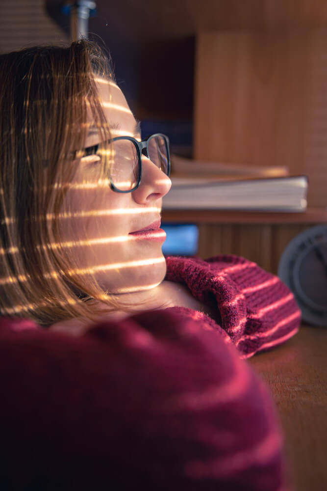 Patient using bright light therapy box in morning to treat seasonal depression symptoms.