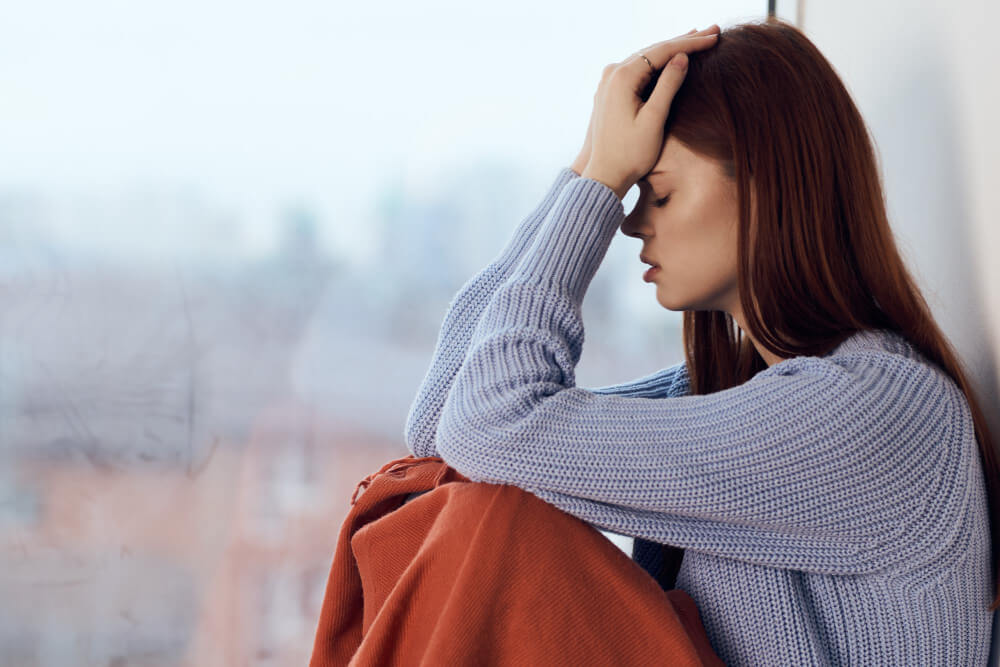 Person experiencing fatigue, oversleeping, and low energy as physical symptoms of seasonal affective disorder.