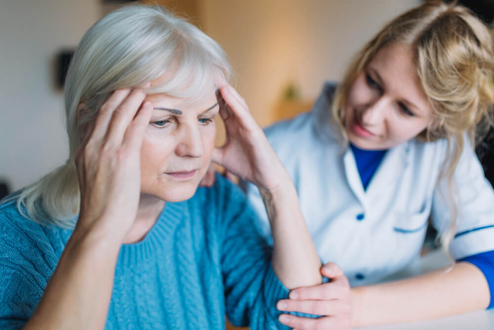 Caregiver assisting elderly dementia patient with daily activities at home