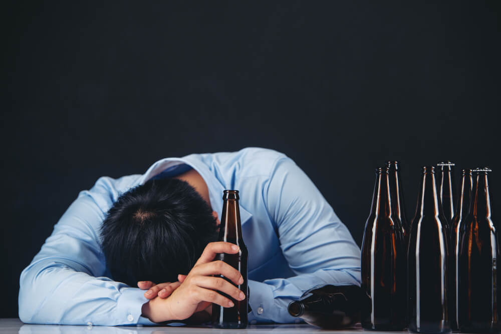 Young adult showing signs of alcohol abuse such as stress, risky behavior, and emotional distress while drinking.
