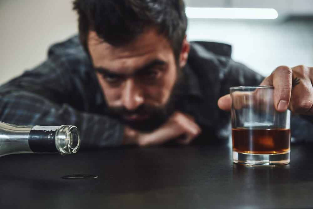 Person struggling with alcohol dependence showing compulsive drinking behavior and loss of control.