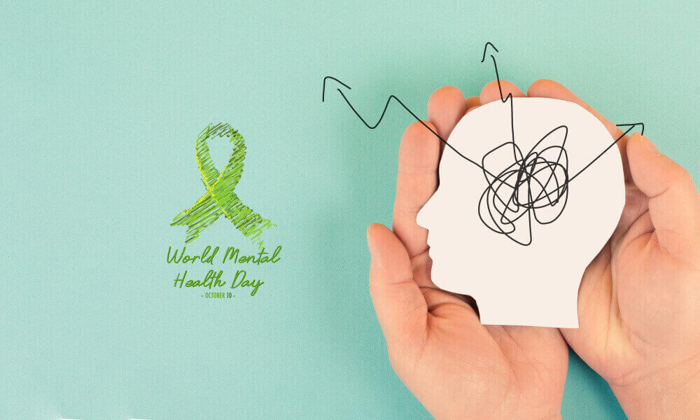 Green mental health awareness ribbon placed beside supportive words about emotional wellness and recovery.